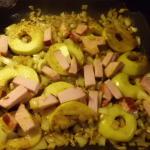 Apfelscheiben Zwiebelwürfel und Kasslerstreifen mit Curry