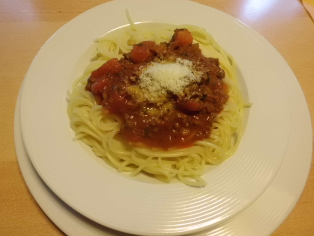 Rezept:Spaghetti Bolognese anrichten und Parmesan drüber streuen