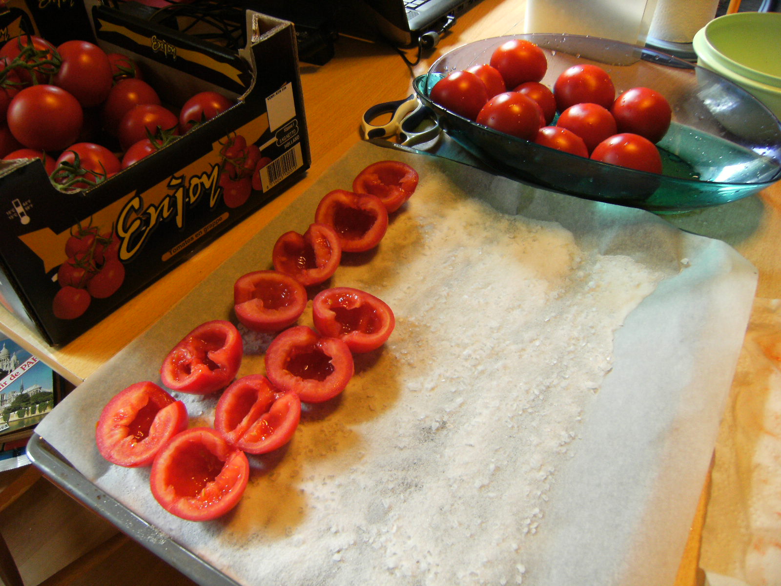 Die Tomatenhälfen mit der Schnittfläche nach oben auf Salzbett legen