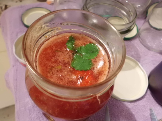 Marmelade eingefüllt in Glas mit Zitronenmelisse