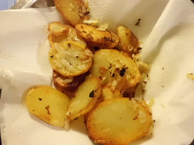 Bratkartoffeln in ein Papiertuch vom überschüßigen Fett entfernen