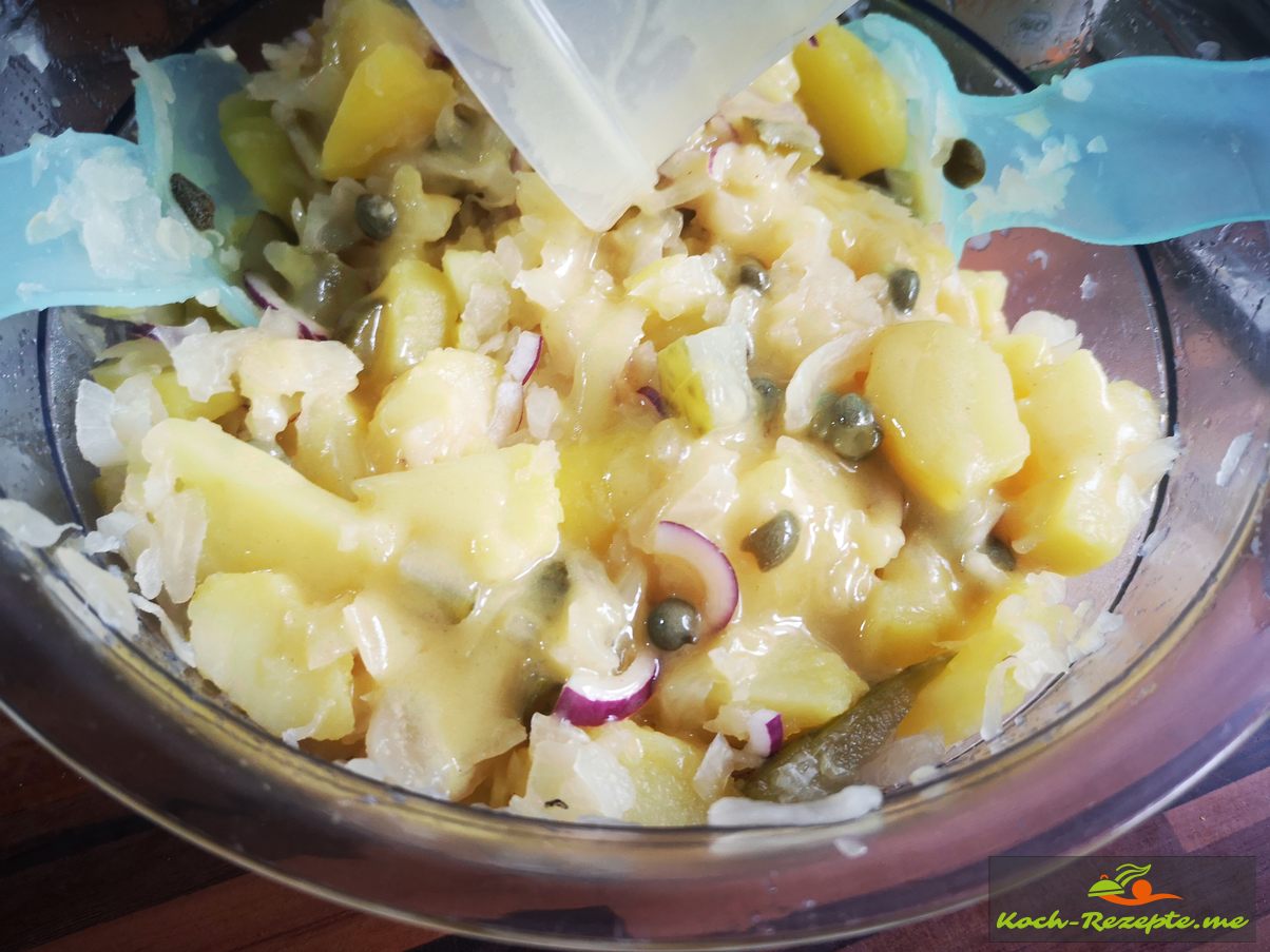 Kartoffel-Sauerkraut Salat frisch und herzhaft lauwarm serviert.