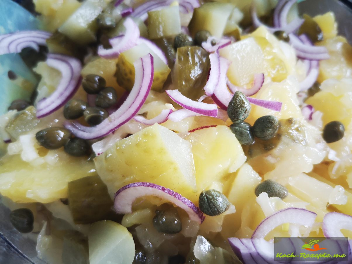 Kartoffel-Sauerkraut Salat frisch und herzhaft lauwarm serviert.